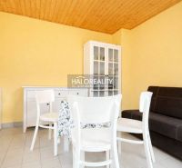 A table with chairs, a dresser, and a sofa in a room with yellow walls.
