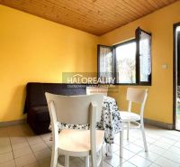 The interior of the garden with white chairs, a table, and yellow walls.