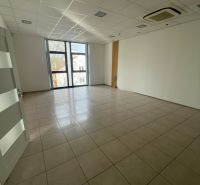 Empty commercial space with a large window, ceramic flooring, and air conditioning.