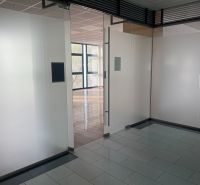 Glass walls and entrance in commercial premises with wood-patterned flooring.