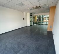 Commercial space with a dark floor, drywall ceiling, and wooden wall decor.
