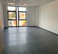Interior of commercial spaces with tiling and a large window for natural light.