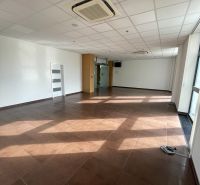 Commercial spaces with brown tiles and white walls, air conditioning on the ceiling.