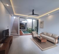 A living room in a villa with a pool and stylish furniture.