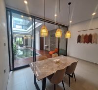 Dining room in the villa with a view of the indoor pool and wall decoration.