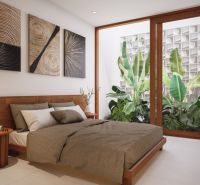 A bedroom in a villa with plants behind large windows and artworks on the wall.