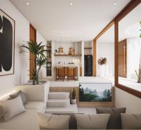 Interior of a villa with a kitchen and living area, decorated with plants and a painting.