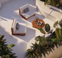 Terrace seating in a villa in Bali with comfortable chairs and a table surrounded by greenery.