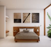 Interior of a villa with a bed, modern art, and large indoor plants.