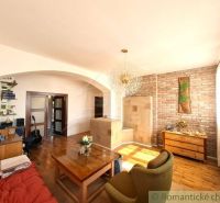 Living room of a family house with a wooden decor floor and a brick wall.