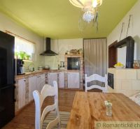 A kitchen in a family house with a wooden floor decor and a traditional stove.