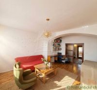Living room in a family house with wood-patterned flooring, a sofa, and a workspace.