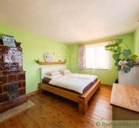 A bedroom in a family house with a stove and a floor with a wooden decor.