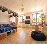 Spacious children's room with wood-patterned flooring, a bed, and decorations.