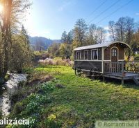 In the gardens around Ľubietová, a wooden caravan by the creek in a picturesque natural setting.