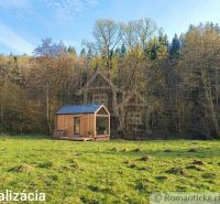 A small wooden house on a meadow surrounded by trees in the Gardens near Ľubietová.