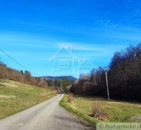 A path leading through nature in the Gardens near Ľubietová with a blue sky and trees.