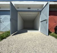 Open garage on Bezručova Street in Trenčín with a white interior and a gravel driveway.