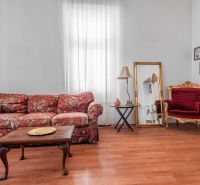 A stylish cottage interior with a floral sofa and a wooden decor floor.