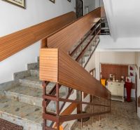 Staircase in a cabin with stone steps and wooden railing.