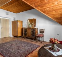 The interior of the cabin with a wooden ceiling, a floor with a wooden decor, and vintage furniture.