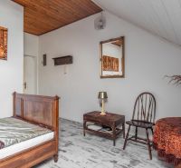 A room with wooden furniture, a floor with a wooden decor, and a decorative table in a cottage.