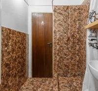 Bathroom in a cottage with marble tiles and a white radiator.