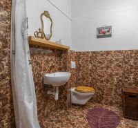 A bathroom in a cabin with marble decor wallpaper, a mirror, and a sink.