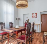 Dining area in a cabin with ornamental furniture and wood-patterned flooring.