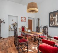 Dining room in a cottage with wooden chairs and a floor with a wooden decor.