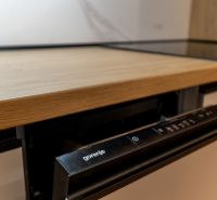 A built-in dishwasher with a wooden decor is installed in the kitchen of a 2-room apartment.