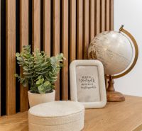 Decorative items on a wooden panel including a globe in a 2-room apartment.