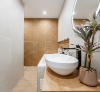 Bathroom in a 2-room apartment with a sink, mirror, and floor with a wood decor.