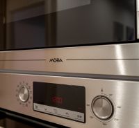 Details of kitchen appliances in a 2-room apartment with a stainless steel surface.