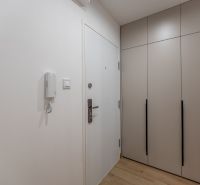 Hallway of a 2-room apartment with a built-in wardrobe and white walls.