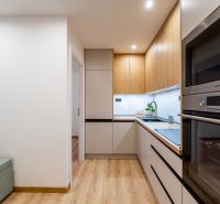 Interior of a 2-room apartment with a kitchen unit and a wooden decor floor.
