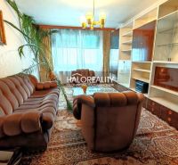 Living room of a 4-room apartment with a wooden decor floor, a sofa, and a dining table.