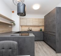 A kitchen in a 2-room apartment with a wooden decor and dark cabinets.
