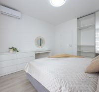 A bright bedroom with a mirrored wardrobe and air conditioning in a 2-room apartment.
