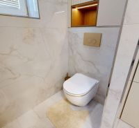 Bathroom toilet with beige walls and a window in a 3-room apartment.