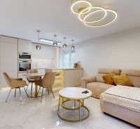 Living room in a three-room apartment with marble flooring and modern lighting.