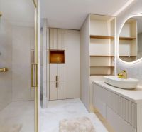 Bathroom in a 3-room apartment with a lighted mirror, shower, and cabinets in neutral shades.