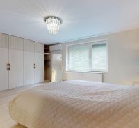 A bedroom with a large wardrobe and a stool in a 3-room apartment.