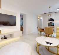 A living room in a 3-room apartment with a white floor, a television, and a kitchenette.