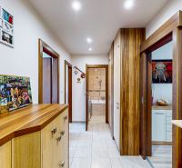 A hallway in a 3-room apartment with a wooden decor floor and built-in wardrobes.