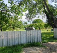 Greenery surrounding the properties - living in Strážske with a metal fence and trees.