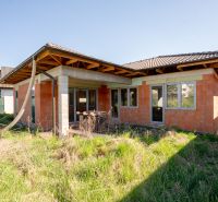 A family house in Drietoma with an unmaintained garden and an unfinished facade.