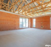 A spacious room in a family house with brick walls and wooden beams.