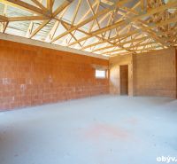 The interior of a family house with exposed roof beams and brick walls.