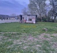 Plots - residential in the village of Slovenská Nová Ves with an old building and grassy vegetation.